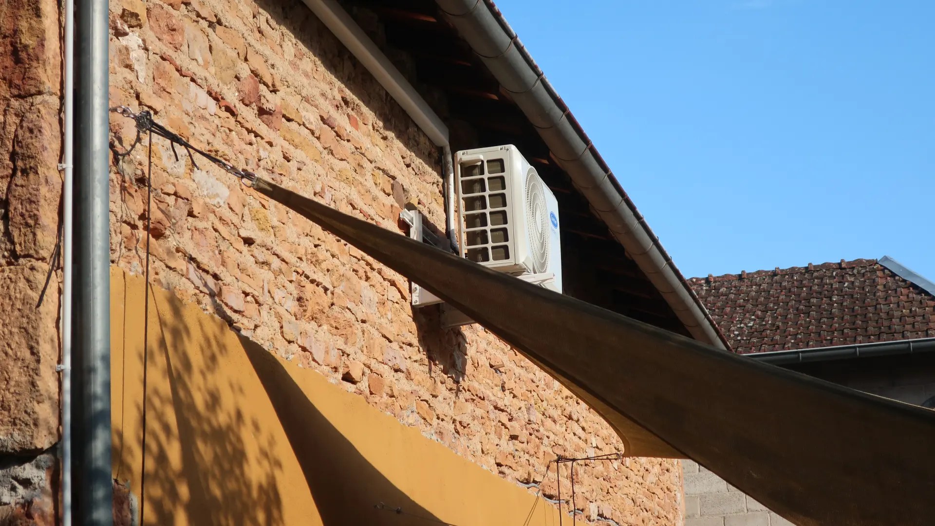 Unité extérieure d'une climatisation installée sur le mur d'un particulier dans le Rhône.